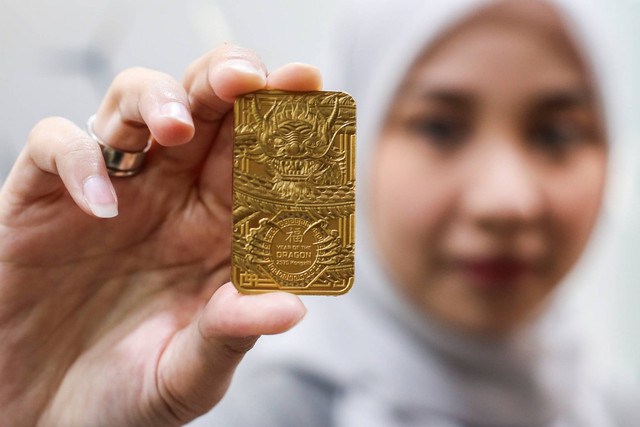 Petugas menunjukkan emas edisi Imlek berupa gambar Naga Kayu di Butik Emas Antam, Setia Budi, Jakarta, Jumat (2/2/2024). Foto: Rivan Awal Lingga/ANTARA FOTO