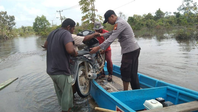 Petugas bantu warga terdampak banjir di Kabupaten Pelalawan, Jumat (9/2).  Foto: Dok. Istimewa
