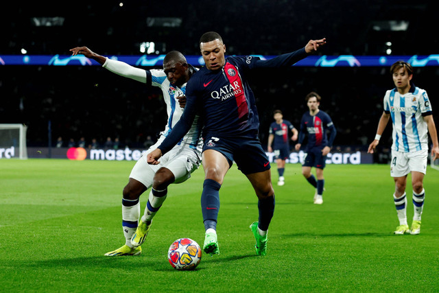 Pemain Paris Saint-Germain Kylian Mbappe berebut bola dengan pemain Real Sociedad Hamari Traore pada pertandingan leg pertama babak 16 besar Liga Champions di Parc des Princes, Paris, Prancis, Kamis (15/2/2024). Foto: Gonzalo Fuentes/REUTERS