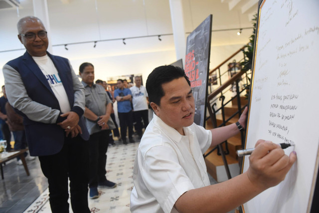 Menteri BUMN Erick Thohir (kanan) disaksikan Direktur Utama Perum LKBN Antara Akhmad Munir (kiri) menuliskan pesan untuk LKBN Antara usai melihat pameran foto Pers Demo-Krasi dan Pembangunan di Galeri Kompleks Antara Heritage Center, Jakarta. Foto: Indrianto Eko Suwarso/Antara Foto