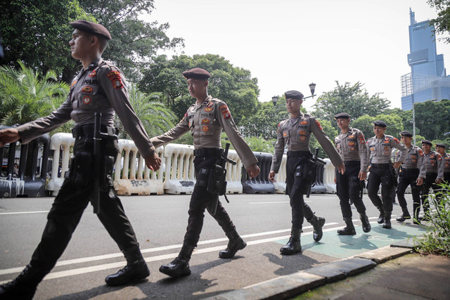 Polisi berjaga saat unjuk rasa di depan Kantor Komisi Pemilihan Umum (KPU), Jakarta, Senin (19/2/2024). Foto: Jamal Ramadhan/kumparan
