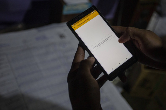 Anggota Kelompok Penyelenggara Pemungutan Suara (KPPS) melengkapi data dari formulir C-Hasil untuk aplikasi Sirekap Pemilu 2024 seusai penghitungan surat suara Dewan Perwakilan Daerah (DPD) RI di TPS 23 Pabean udik, Indramayu, Jawa Barat. Foto: Dedhez Anggara/Antara Foto