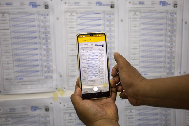 Petugas KPPS mengambil gambar hasil penghitungan suara saat simulasi di Indramayu, Jawa Barat, Rabu (7/2/2024). Foto: Dedhez Anggara/Antara Foto