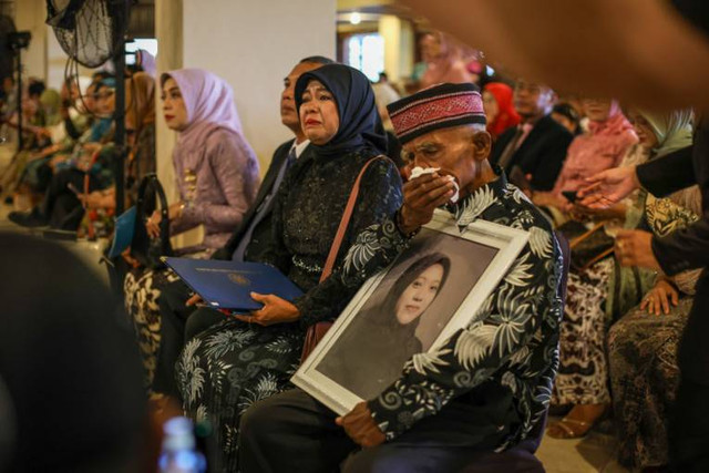 Ngadinah dan Jono, orang tua Dewi Sekar Rumpaka, tak kuasa menahan tangis saat menghadiri wisuda anaknya di UGM, Rabu (21/2). Foto: Dok. UGM