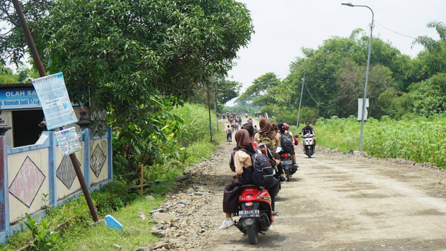 Para siswa di SMP Negeri 2 Prambanan, Sleman, saat pulang sekolah dan melewati jalan yang rusak akibat tambang ilegal. Foto: Widi RH Pradana/Pandangan Jogja