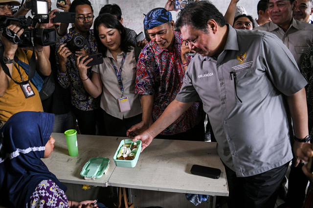 Menko Perekonomian Airlangga Hartarto melihat menu makanan milik siswa saat simulasi program makan siang gratis di SMP Negeri 2 Curug, Kabupaten Tangerang, Banten, Kamis (29/2/2024). Foto: Sulthony Hasanuddin/Antara Foto