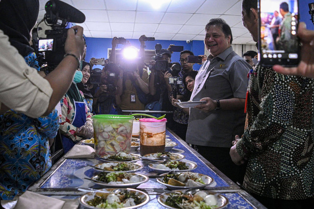 Menko Perekonomian Airlangga Hartarto mencicip makanan saat simulasi program makan siang gratis di SMP Negeri 2 Curug, Kabupaten Tangerang, Banten, Kamis (29/2/2024). Foto: Sulthony Hasanuddin/Antara Foto