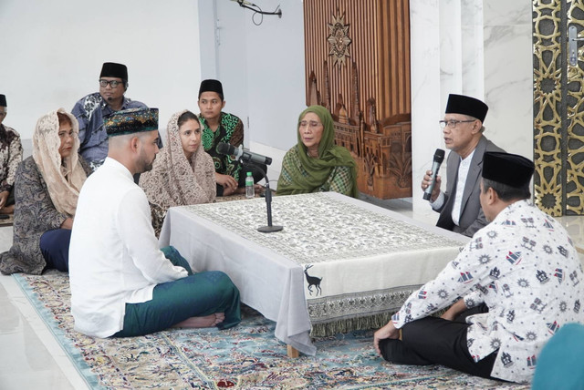 Ikrar syahadat Geoffrey Alain Gerald dibimbing Haedar Nashir. Susi Pudjiastuti dan Nadine Kaiser turut menyaksikan. Dok: muhammadiyah.or.id