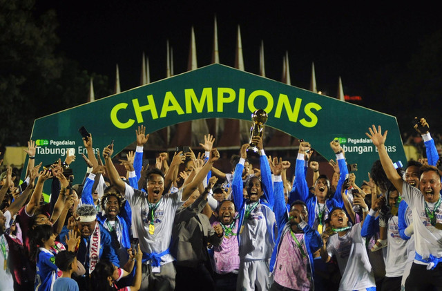 Pesepak bola PSBS Biak dan ofisial mengangkat piala usai menjadi juara pertama Liga 2 di Stadion GOR H Agus Salim Padang, Sumatera Barat, Sabtu (9/3/2024). Foto: Iggoy el Fitra/ANTARA FOTO