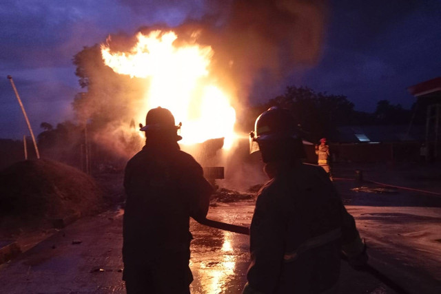 Petugas pemadam kebakaran berusaha memadamkan truk pengisi Bahan Bakar Minyak (BBM) yang terbakar di SPBU Gandoang, Kecamatan Cileungsi, Kabupaten Bogor, Senin (11/3/2024). Foto: Damkar Cileungsi