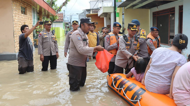 Kapolres Bojonegoro AKBP Mario Prahatinto, saat bagikan nasi bungkus keapda warga terdampak luapan banjir sungai Bengawan Solo di Kelurahan Ledokwetan, Kecamatan Kota Bojonegoro. Senin (11/03/2024). (Aset: Istimewa)
