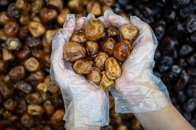 Pedagang menata buah kurma di salah satu toko kurma kawasan Pasar Tanah Abang, Jakarta, Selasa,(12/3/2024). Foto: Erlangga Bregas Prakoso/ANTARA FOTO