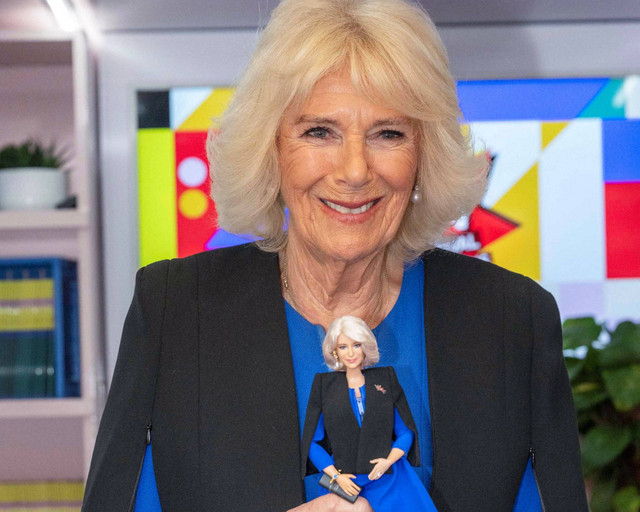 Ratu Inggris Camilla memegang boneka Barbie dirinya saat Hari Perempuan Internasional di Istana Buckingham, pusat kota London, pada Selasa (12/3/2024). Foto: Paul Grover/AFP