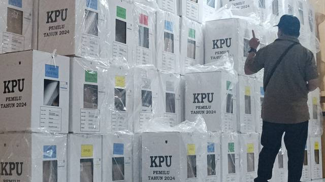 Seorang petugas menghitung jumlah kotak suara pada Pemilu 2024.