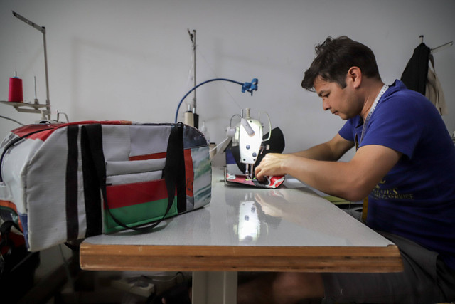 Pekerja menyelesaikan pembuatan tas berbahan baliho bekas kampanye pemilu di Liberty Society, Kabupaten Tangerang, Banten, Jumat (15/3/2024). Foto: Jamal Ramadhan/kumparan