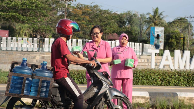 Ketua Bhayangkari Cabang Sekadau Echa Nyoman Sudama menyerahkan takjil kepada salah seorang pengendara. Foto: Dok. Polres Sekadau