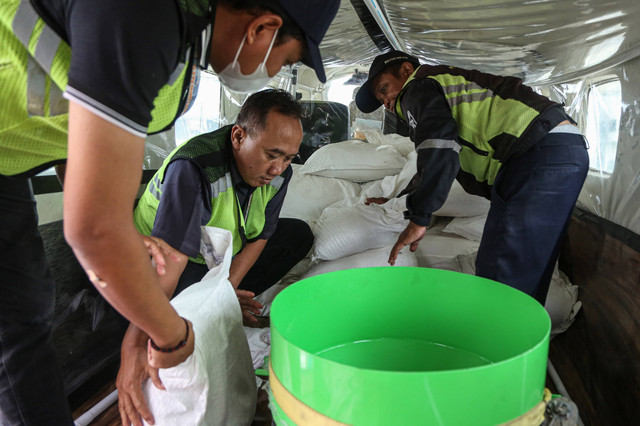 Petugas memasukkan garam ke dalam pesawat Cessna 208B Grand Caravan EX untuk persemaian garam dengan Teknologi Modifikasi Cuaca (TMC) di Bandara Internasional Ahmad Yani, Semarang, Jawa Tengah, Senin (18/3/2024). Foto: Makna Zaezar/Antara Foto