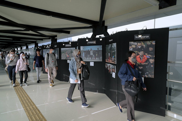 Pengunjung mengamati karya pameran foto kumparan Photography Exhibition di Jembatan Interkoneksi MRT ASEAN, Jakarta, Senin (18/3/2024). Foto: Jamal Ramadhan/kumparan
