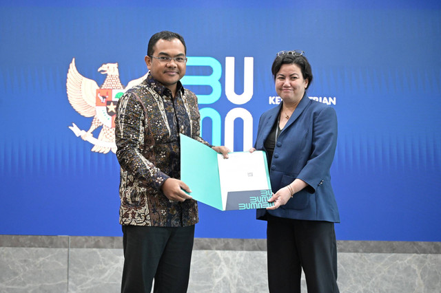 Deputi Bidang Manajemen Sumber Daya Manusia, Teknologi, dan Informasi Kementerian BUMN Tedi Bharata (kiri) saat menyerahkan keputusan Rapat Umum Pemegang Saham pengangkatan Nawal Nely (kanan) sebagai Komisaris PLN. Foto: Dok. PLN