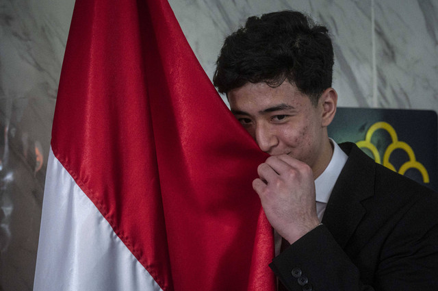 Pesepak bola Cyrus Margono mencium bendera merah putih usai pembacaan sumpah menjadi Warga Negara Indonesia (WNI) di Kantor Kanwil Kemenkumham DKI Jakarta, Cawang, Jakarta, Kamis (21/3). Foto: ANTARA FOTO/Aprillio Akbar