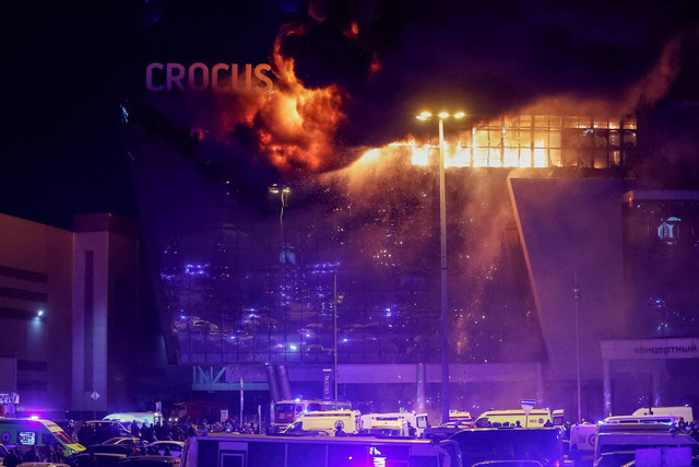 Ambulans dan kendaraan layanan darurat Rusia diparkir di luar tempat konser Balai Kota Crocus yang terbakar menyusul insiden penembakan, di luar Moskow, Rusia, Jumat (22/3/2024). Foto: Yulia Morozova/REUTERS