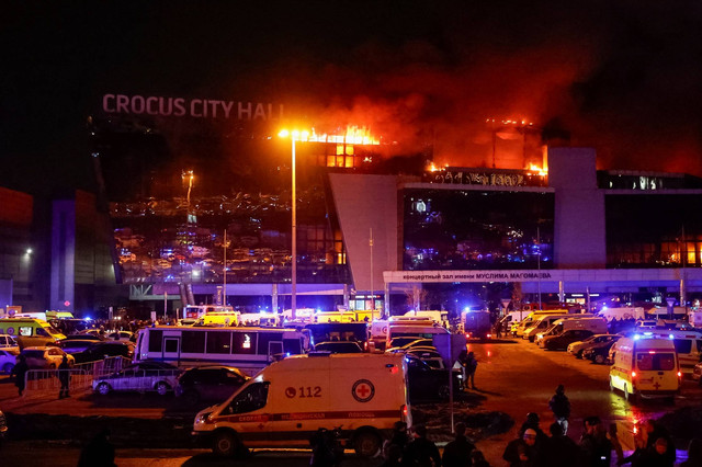 Ambulans dan kendaraan layanan darurat Rusia diparkir di luar tempat konser Balai Kota Crocus yang terbakar menyusul insiden penembakan, di luar Moskow, Rusia, Jumat (22/3/2024). Foto: Yulia Morozova/REUTERS