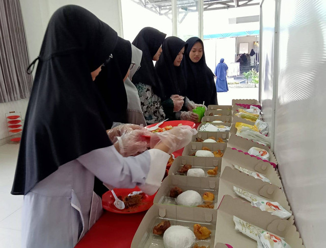 Para santri ponpes Alif Laam Miim saat belajar mengemas nasi kotak. Foto: Masruroh/Basra