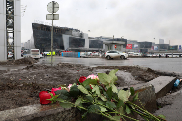 Warga meletakkan bunga di tugu peringatan darurat di depan Balai Kota Crocus, Sehari setelah serangan senjata di Krasnogorsk, luar Moskow, Sabtu (23/3/2024) Foto: STR/AFP