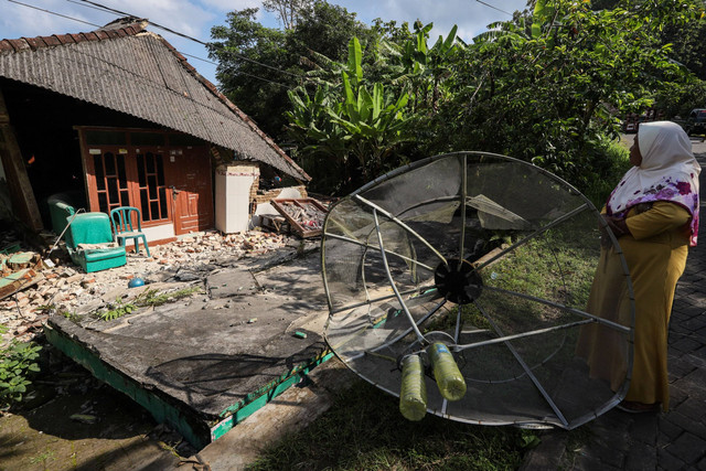 Warga mengamati rumah yang mengalami kerusakan akibat gempa di Dusun Prapat Tunggal, Sangkapura, Pulau Bawean, Gresik, Jawa Timur, Minggu (24/3/2024). Foto: Rizal Hanafi/ANTARA FOTO