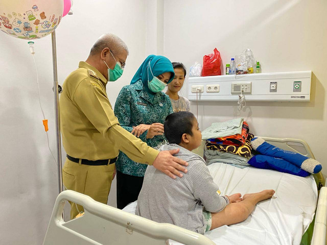 Adrian, anak penderita Leukemia yang saat ini jalani Kemoterapi di RSUD Soedarso merasa senang mendapat kado dan bisa fot bareng Pj Gubernur Kalbar. Foto: Yulia Ramadhiyanti/Hi!Pontianak