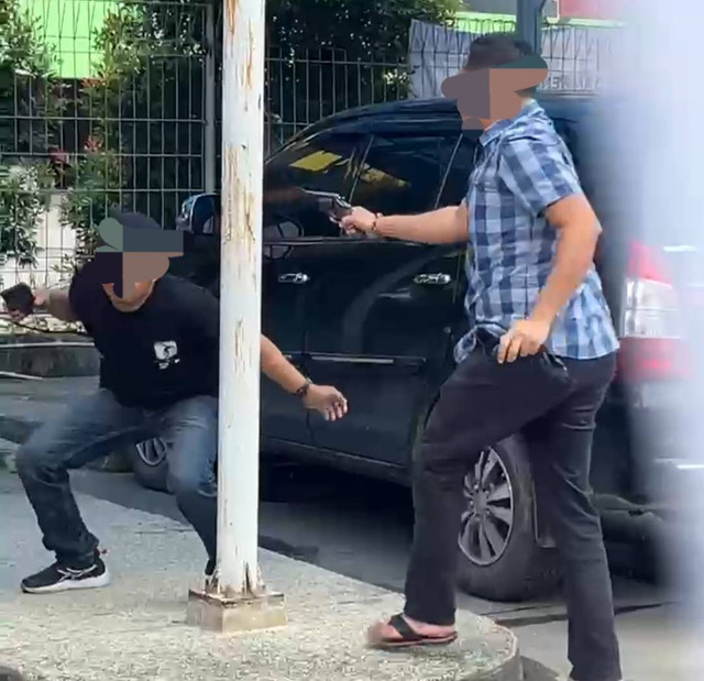 Aiptu Fandi saat todongkan senpi ke salah satu debt collector. (ist)