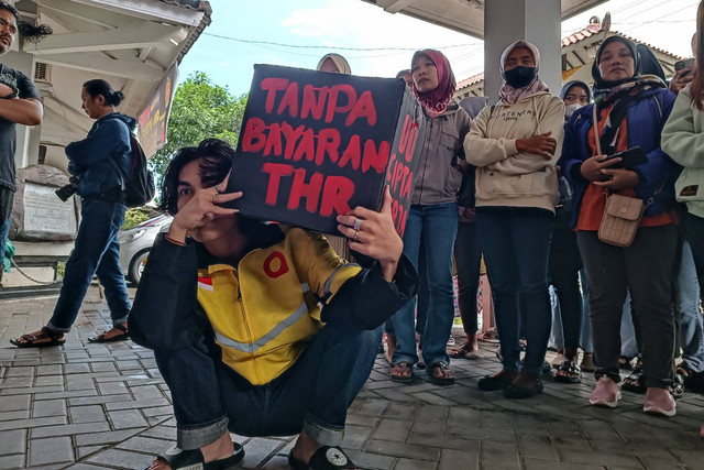Sejumlah buruh menggelar aksi di kantor Disnakertrans DIY, di Ring Road Timur, Kabupaten Sleman, Kamis (28/3/2024). Foto: Arfiansyah Panji Purnandaru/kumparan