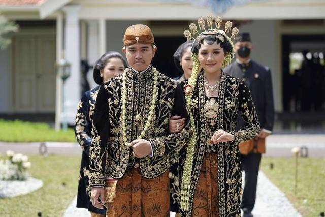 Putra bungsu Presiden Joko Widodo, Kaesang Pangarep (kiri) bersama Erina Gudono (kanan) berjalan menuju lokasi resepsi Tasyakuran di Pura Mangkunegaran, Solo, Jawa Tengah, Minggu (11/12/2022). Foto: Dhemas Reviyanto/Antara Foto