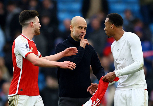 Pep Guardiola bicara dengan Gabriel Magalhaes dan Declan Rice usai laga Man City vs Arsenal dalam lanjutan Liga Inggris 2023/24 di Stadion Etihad pada Minggu (31/3) malam WIB. Foto: REUTERS/Carl Recine