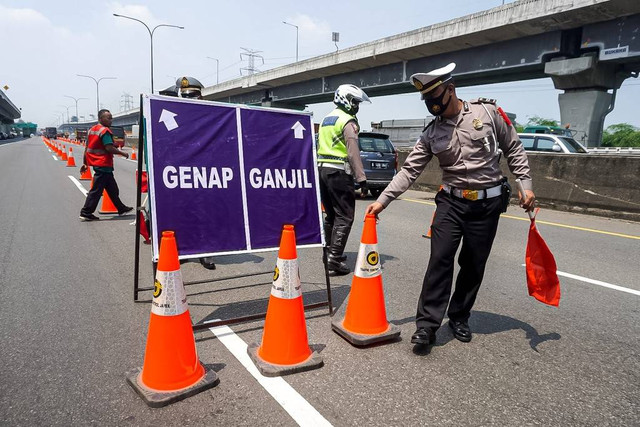 Polisi mengatur arus lalu lintas saat penerapan ganji genap di Tol Cikampek KM 47, Jawa Barat, Senin (25/4). Foto: Iqbal Firdaus/kumparan