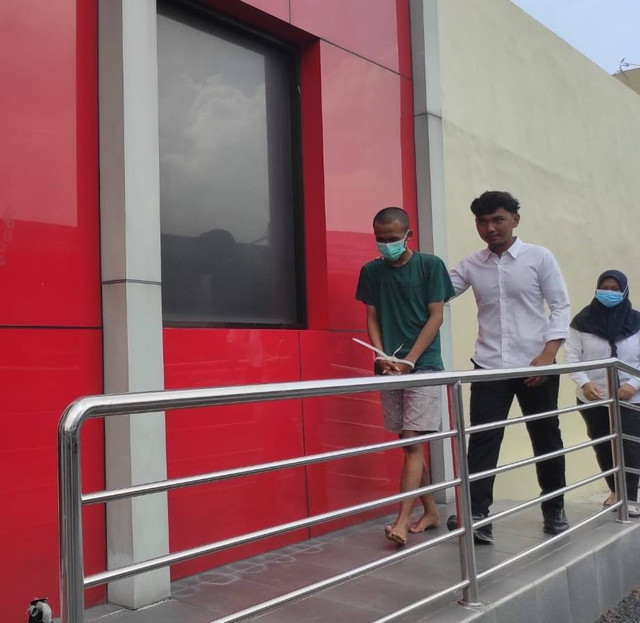 Rizal penjual istri (kiri) dikawal dua polisi. Dok: mili.id