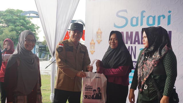 Asisten Bidang Ekonomi dan Pembangunan Suhermi, Manager CSR Pertamina, Dian Hapsari Firasati (kiri) bersama Plt. Bupati Kampar, Hambali (kedua kiri) dalam membagikan paket sembako murah pada kegiatan Safari Ramadan BUMN 2024, di kawasan Bangkinang Riverside, Kampar, Riau, Selasa (2/4/2024). Foto: Dok. Pertamina
