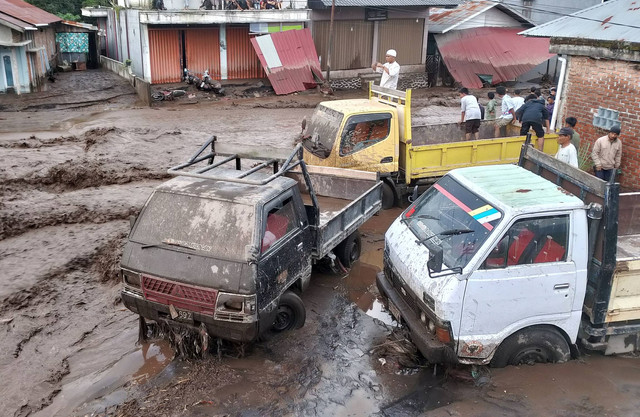 Sejumlah warga menyaksikan kondisi mobil truk yang terdampak banjir lahar dingin di Nagari Bukik Batabuah, Kecamatan Canduang, Agam, Sumatera Barat, Jumat (5/4/2024). Foto: Al Fatah/ANTARA FOTO