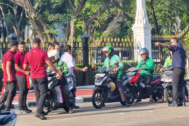 Presiden Jokowi membagikan sembako kepada warga di depan Istana Merdeka, Senin (8/4/2024) Foto: Nadia Riso/kumparan