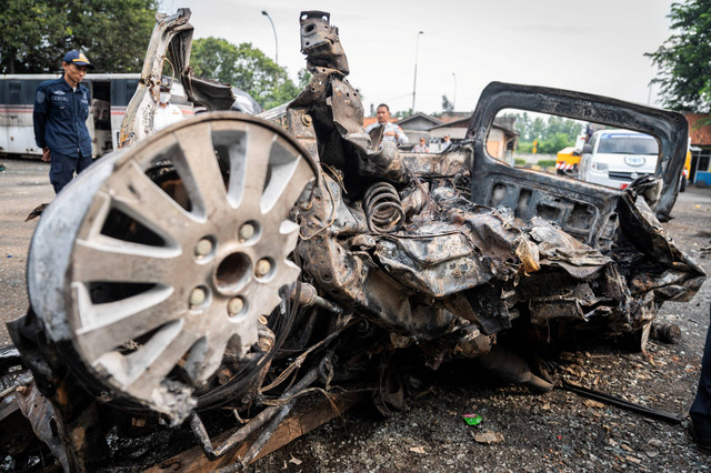Seorang petugas melihat bangkai kendaraan pascakecelakaan di Tol Jakarta-Cikampek KM 58 di Pool Derek Cikopo, Purwakarta, Jawa Barat, Senin (8/4/2024). Foto: Bayu Pratama S/ANTARA FOTO
