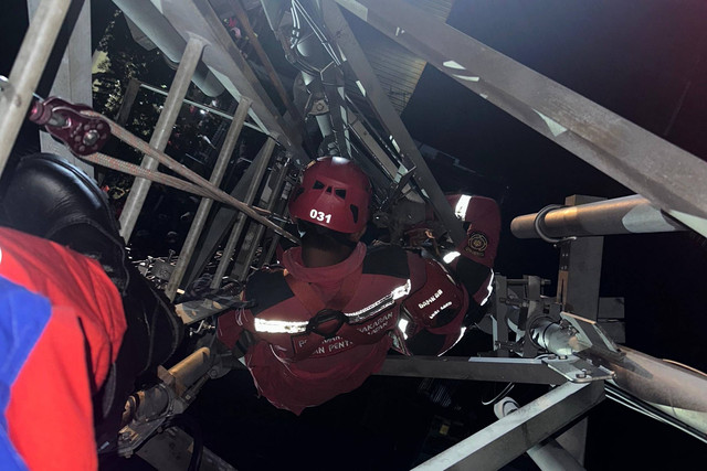 Petugas mengevakuasi pria mabuk lem yang panjat tower listrik. Foto: Dok. Istimewa