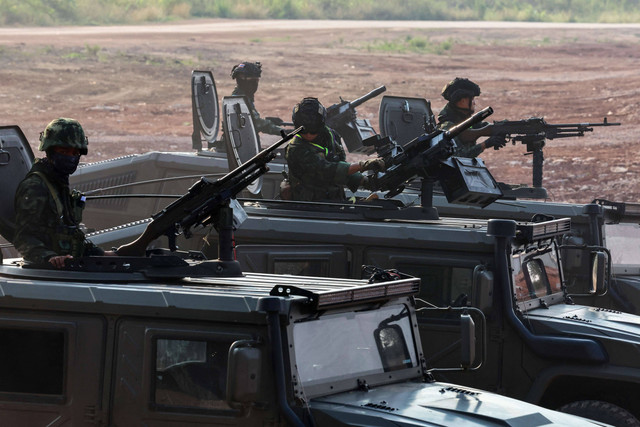 Personel militer berjaga saat ratusan pengungsi menyeberangi perbatasan sungai antara Myanmar dan Thailand, kota perbatasan strategis ke tangan pemberontak yang memerangi junta militer Myanmar, di Mae Sot, Provinsi Tak, Thailand, Sabtu (13/4/2024) Foto: Athit Perawongmetha/Reuters