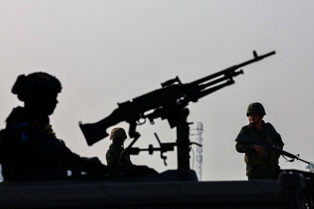 Personel militer berjaga saat ratusan pengungsi menyeberangi perbatasan sungai antara Myanmar dan Thailand, kota perbatasan strategis ke tangan pemberontak yang memerangi junta militer Myanmar, di Mae Sot, Provinsi Tak, Thailand, Sabtu (13/4/2024) Foto: Athit Perawongmetha/Reuters