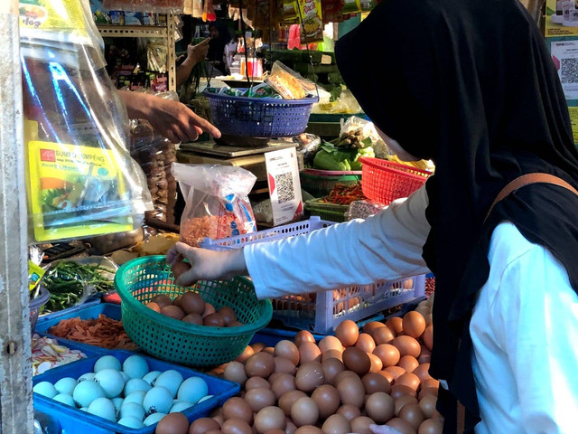 Foto: Seorang ibu sedang membeli bahan makanan di pasar menjelang lebaran.
