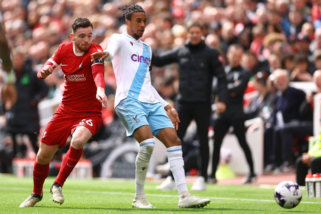 Pemain Liverpool Andrew Robertson berebut bola dengan pemain Crystal Palace Michael Olise pada pertandingan lanjutan Liga Inggris di Anfield, Liverpool, Inggris, Minggu (14/4/2024). Foto: Carl Recine/REUTERS