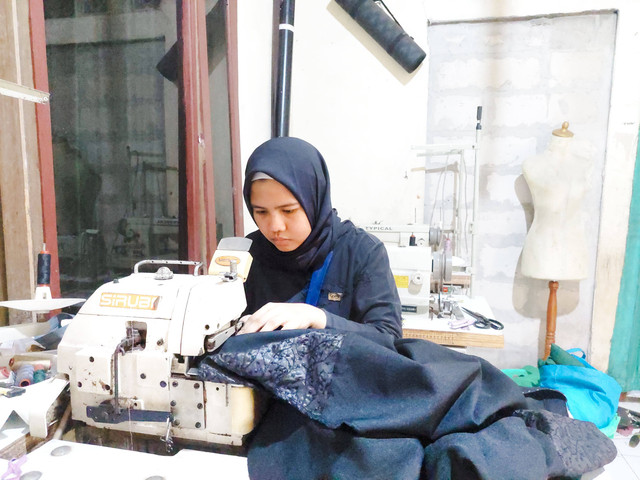 Ulan (28) saat memermak baju gamis milik pelanggan saat menjelang Lebaran. Foto: Mayang Suwita