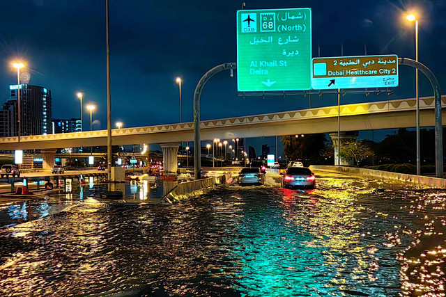 Pengendara berkendara di sepanjang jalan yang banjir menyusul hujan lebat di Dubai (17/4/2024) Foto: GIUSEPPE CACACE / AFP