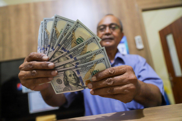 Petugas menujukkan pecahan mata uang Dolar AS di salah satu gerai penukaran mata uang di kawasan Kemang, Jakarta, Rabu (17/4/2024). Foto: Iqbal Firdaus/kumparan