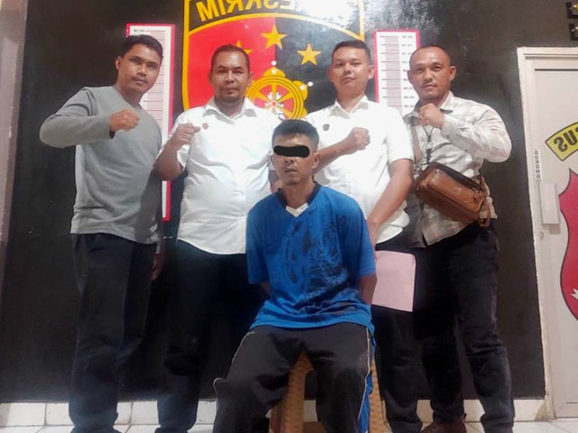 Polisi saat mengamankan MY yang dilaporkan istrinya karena menghamili anak tiri. (ist)