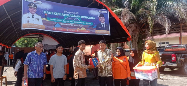 Sekretaris BPBD Sumsel, Askoni saat memberikan bantuan ke korban banjir bandang di simulasi, Foto : Abdul Toriq/Urban Id